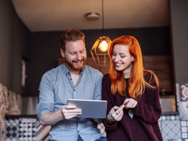 Young couple in kitchen on a tablet computer